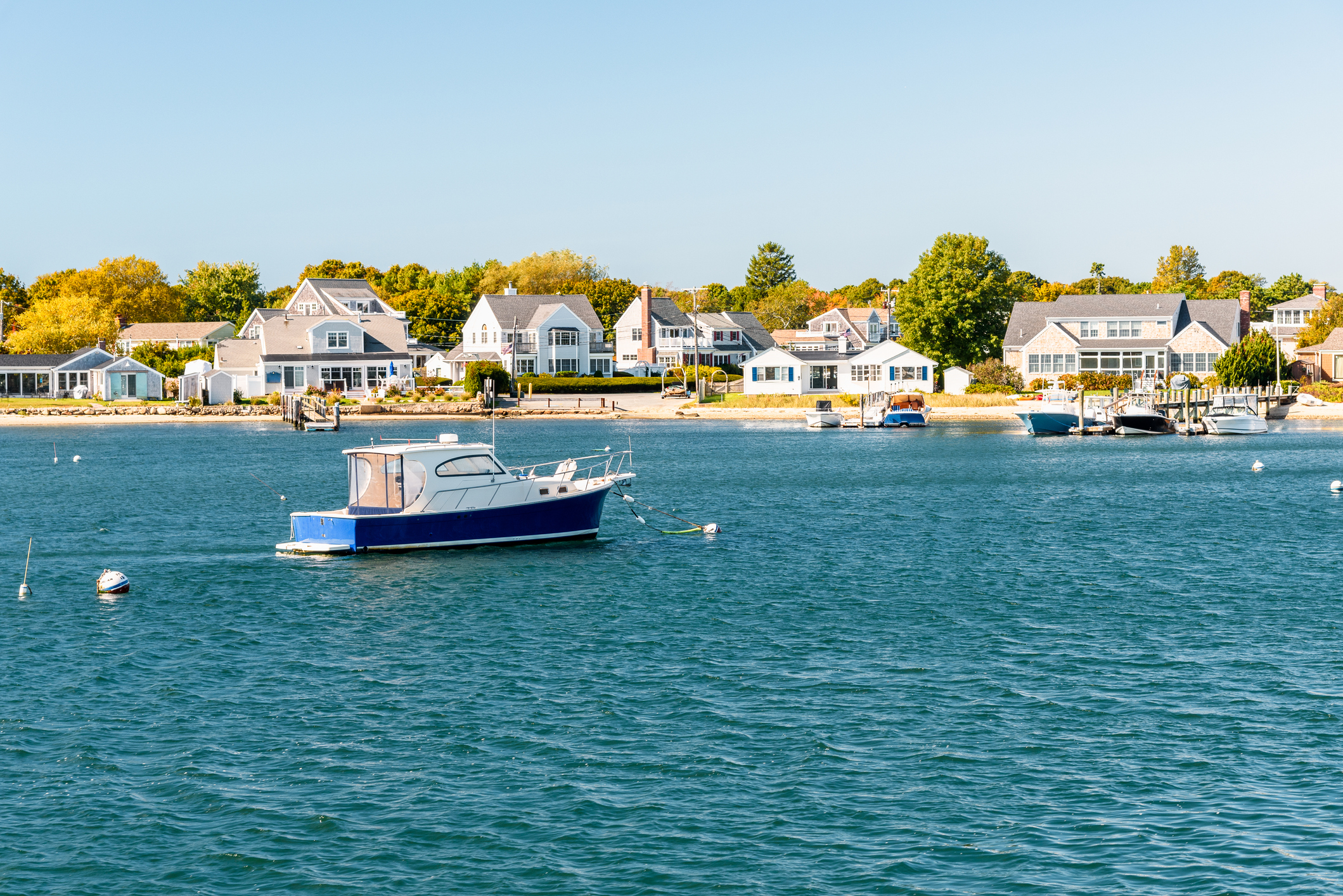 Motorboat moored off a built up coast on a sunny autumn day Motorboat moored off a built up coast on a sunny autumn day
